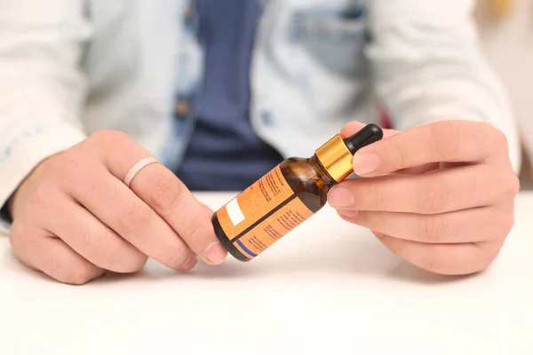 Elinde tutan ilaç şişesini bırakan bir adamın resmi. Beyaz arka planda yalıtılmış.