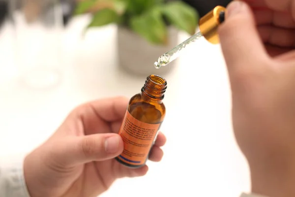 Elinde tutan ilaç şişesini bırakan bir adamın resmi. Beyaz arka planda yalıtılmış.