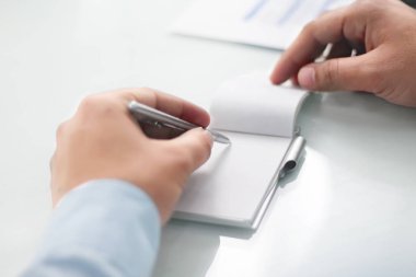 Kalemle evrak işi çalışan adamın resmi. Beyaz arka planda yalıtılmış.