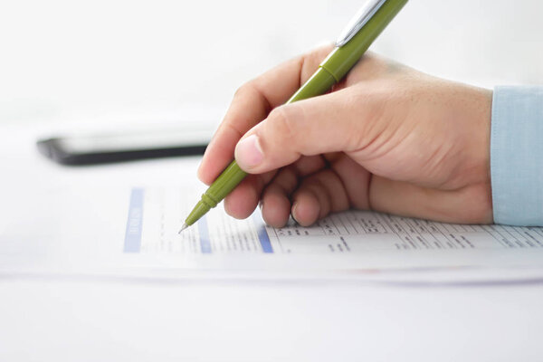 Picture of man working paperwork with pen. Isolated on white background.