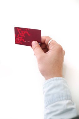 Kredi kartını elinde tutan bir adamın resmi. Beyaz arkaplanda izole.