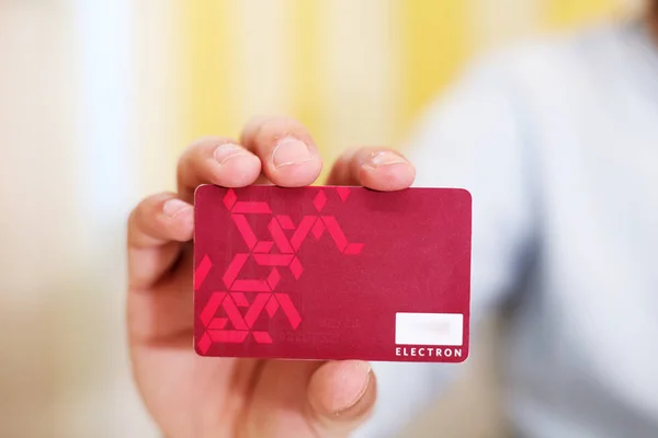 Kredi kartını elinde tutan bir adamın resmi. Beyaz arkaplanda izole.