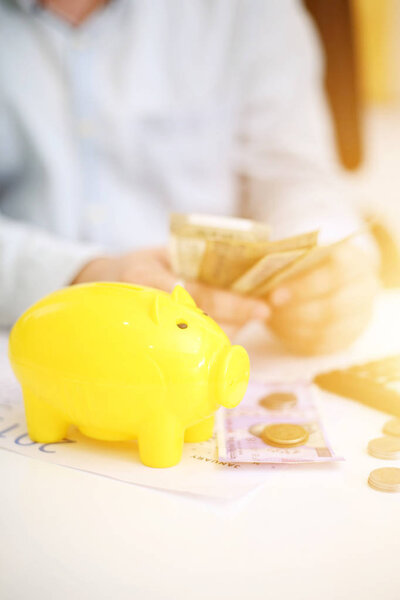  Фото человека, кладущего деньги в желтую копилку. Изолированный на заднем плане
.