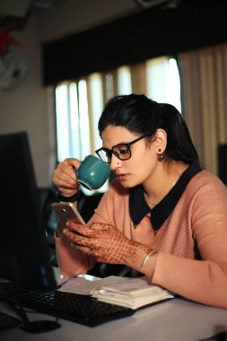 Masada oturan genç iş kadını ofiste bilgisayar kullanıyor, modern yönetici kız..