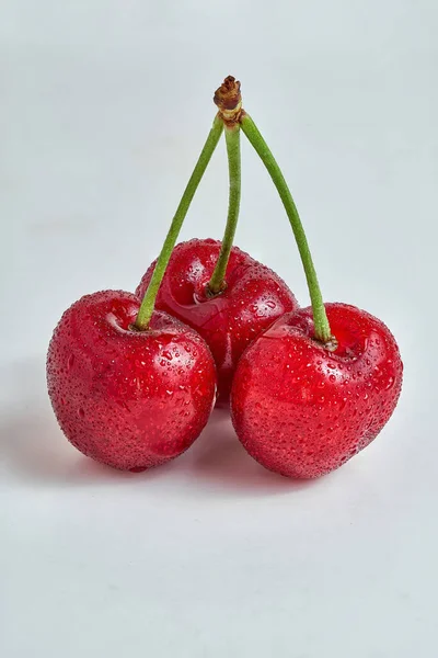 Ein Bund Von Drei Kirschen Saisonales Obst Isoliert Auf Weißem lizenzfreie Stockfotos