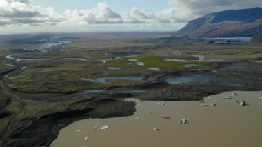 Suyun havadan görünüşü bir vadideki yeşil çayırlarda yolunu buluyor.