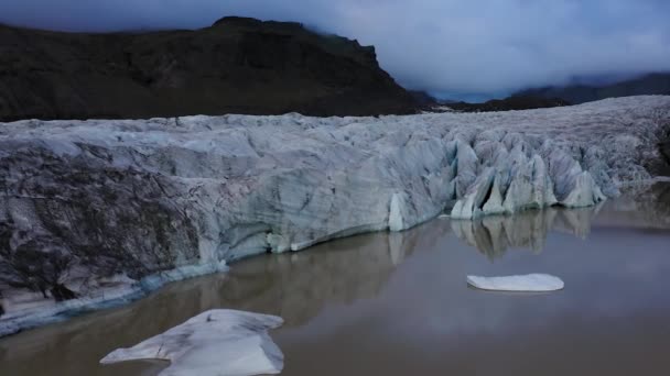 4K κεραία ενός όμορφου παγετώνα στην Ισλανδία με σκούρα γκρι σύννεφα — Αρχείο Βίντεο