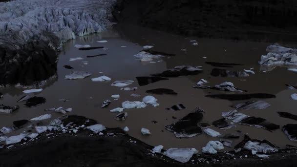 アイスランドのラグーンを飛んで、日没時に小さな融解氷山で満たされます。. — ストック動画