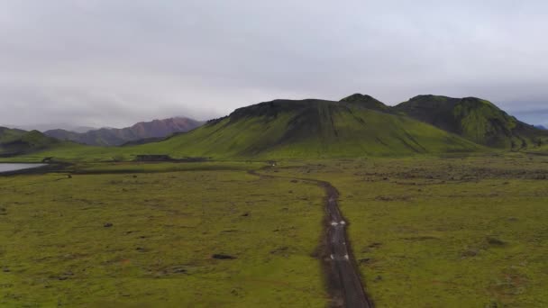 Aérien de voiture conduisant sur un chemin de terre avec une belle chaîne de montagnes — Video