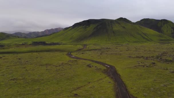 Aérea de coche que conduce por el camino de tierra con una hermosa cordillera — Vídeo de stock