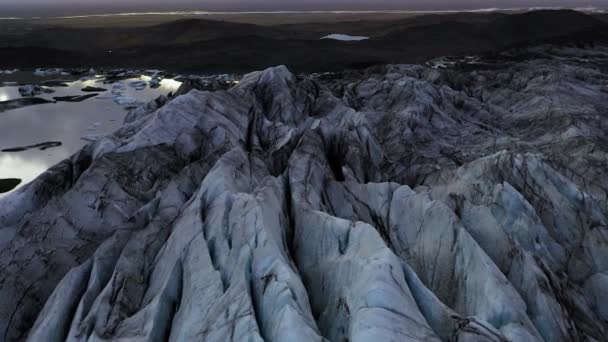 Voando sobre uma lagoa na Islândia cheia de pequenos icebergs derretendo ao pôr do sol . — Vídeo de Stock