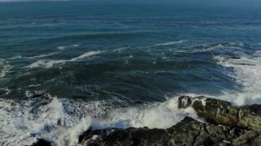 Kayalara çarpan dalgaların hava görüntüsü. 4k stok görüntüsü