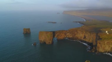 Gün batımında Dyrholaey 'deki kayalık uçurumun havadan görüntüsü..