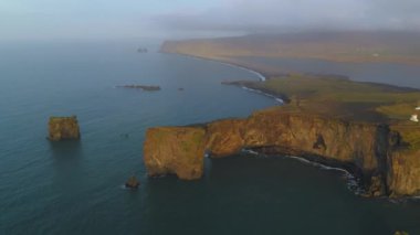 Gün batımında Dyrholaey 'deki kayalık uçurumun havadan görüntüsü..