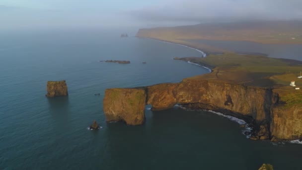 Widok z lotu ptaka skalistego klifu na cyplu Dyrholaey o zachodzie słońca. — Wideo stockowe