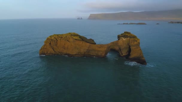 Vista aérea de la pequeña isla rocosa junto a Dyrholaey, Islandia — Vídeo de stock