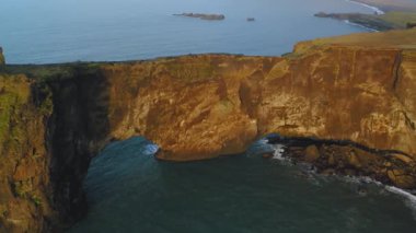 Gün batımında Dyrholaey 'deki kayalık uçurumun havadan görüntüsü..