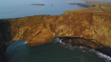 Gün batımında Dyrholaey 'deki kayalık uçurumun havadan görüntüsü..