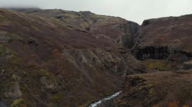 Kayalık dağlar ve İzlanda arasında dönen küçük nehrin hava manzarası.