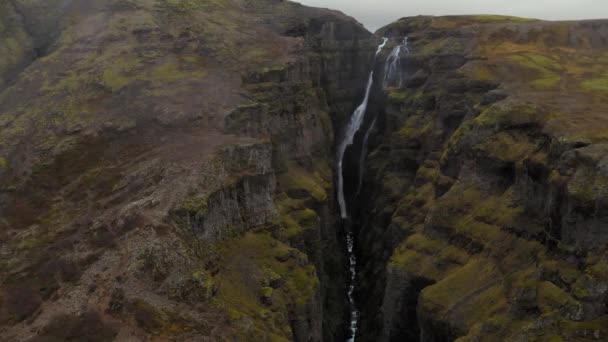 Luchtfoto van de rotsachtige groene Fjadrargljufur Canyon in IJsland met een waterval — Stockvideo
