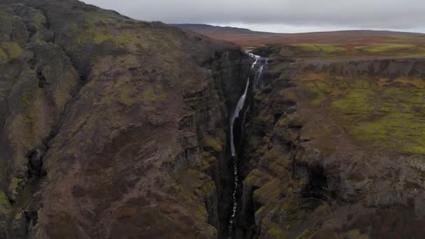 Vue aérienne du canyon vert rocheux Fjadrargljufur en Islande avec une chute d'eau