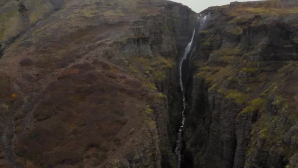 Luchtfoto van de rotsachtige groene Fjadrargljufur Canyon in IJsland met een waterval — Stockvideo