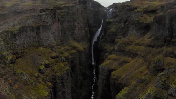 Luchtfoto van de rotsachtige groene Fjadrargljufur Canyon in IJsland met een waterval — Stockvideo