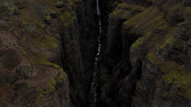 Luchtfoto van de rotsachtige groene Fjadrargljufur Canyon in IJsland met een waterval — Stockvideo