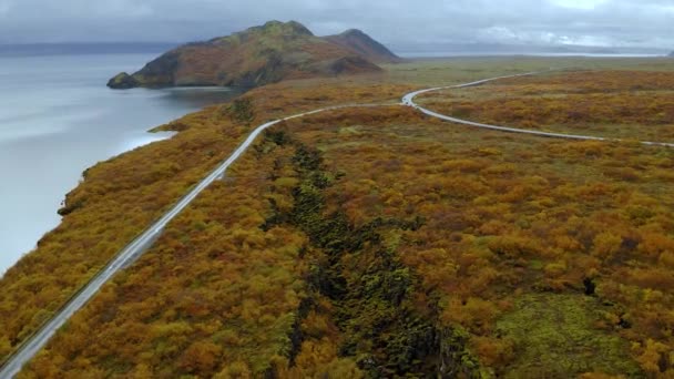 Foto aérea de camino islandés a través de los fiordos en otoño con impresionantes montañas y mar — Vídeo de stock