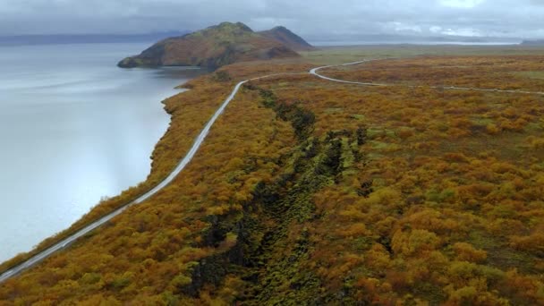 Luftaufnahme der isländischen Straße durch die Fjorde im Herbst mit atemberaubenden Bergen und Meer — Stockvideo