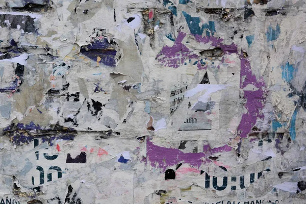 創造的で抽象的な背景としての古い壁にカラフルな引き裂かれたポスター ストック画像