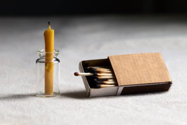 Masanın üzerinde karanlık bir odada soyu tükenmiş bir mum var. Kutunun dışında yanmış yapışma arasında tek bir çalışma maç canlanma ve gelişme için bir şans sembolize.