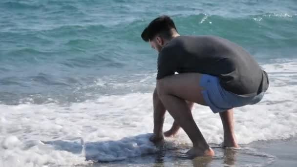 年轻的运动男子在海滩上散步 — 图库视频影像