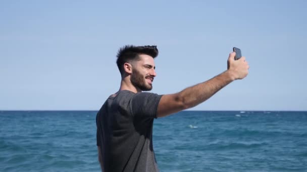 Joven en la playa tomando foto selfie — Vídeo de stock