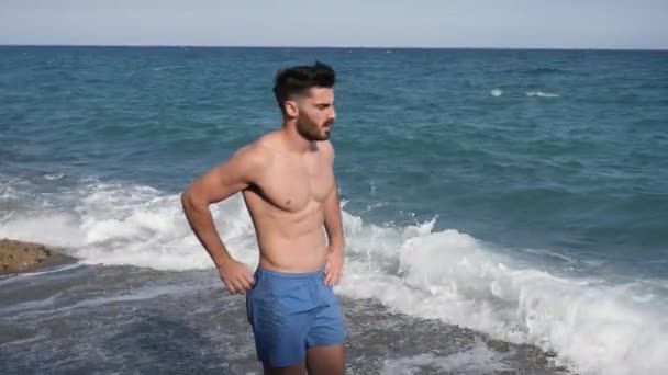 Csinos, fiatal férfi harapás a csokoládé, tenger mellett — Stock videók