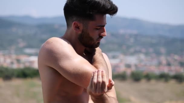 Jeune homme torse nu portant de la crème solaire — Video
