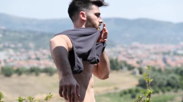 Привабливий м'язистий молодий чоловік одягається — стокове відео