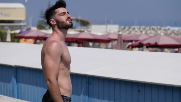 Attractive muscular young man on seaside promenade — Stock Video