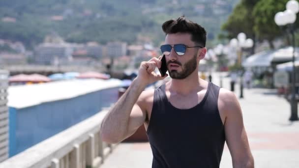Atletický muž u moře volá na mobil — Stock video