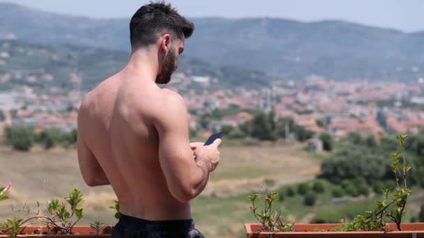 Молодой человек использует мобильный телефон, чтобы сфотографировать пейзаж — стоковое видео