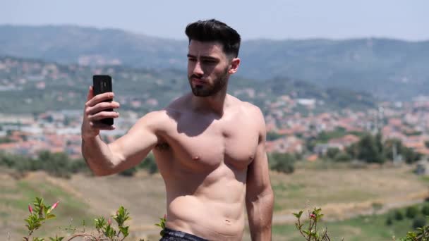 Νεαρός άνδρας που χρησιμοποιούν κινητό τηλέφωνο για να πάρει selfie — Αρχείο Βίντεο