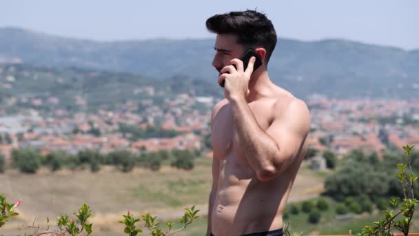 Młody człowiek za pomocą telefonu komórkowego, aby zadzwonić do kogoś — Wideo stockowe
