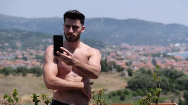 Молодой человек использует мобильный телефон для видеозвонков — стоковое видео