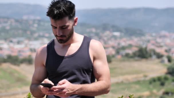 İleti göndermek için cep telefonu kullanan genç adam — Stok video