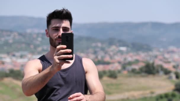 Görüntülü görüşme yapmak için cep telefonu kullanan genç adam — Stok video