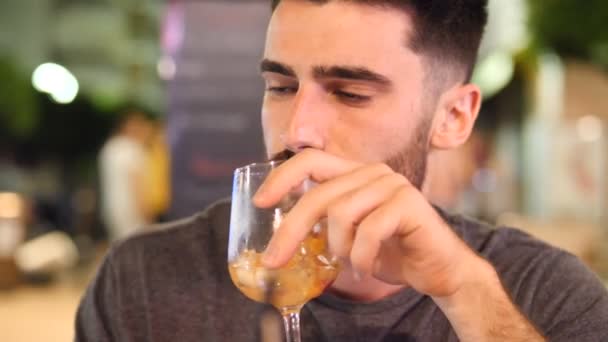 Jonge man buiten cocktail drinken in de nacht — Stockvideo