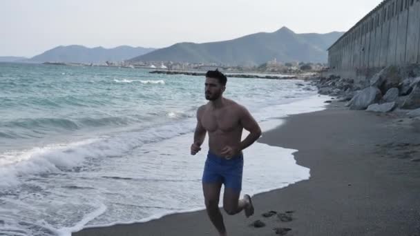 Νεαρός άνδρας στην παραλία τρέχει — Αρχείο Βίντεο