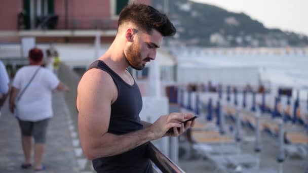 Homme utilisant un téléphone portable pour prendre une photo de la mer — Video