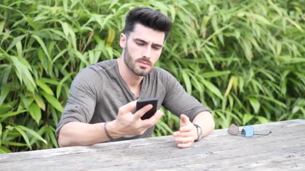 Hombre joven usando el teléfono celular para tomar selfie — Vídeo de stock