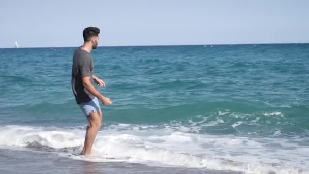 年轻的运动男子在海滩上散步 — 图库视频影像